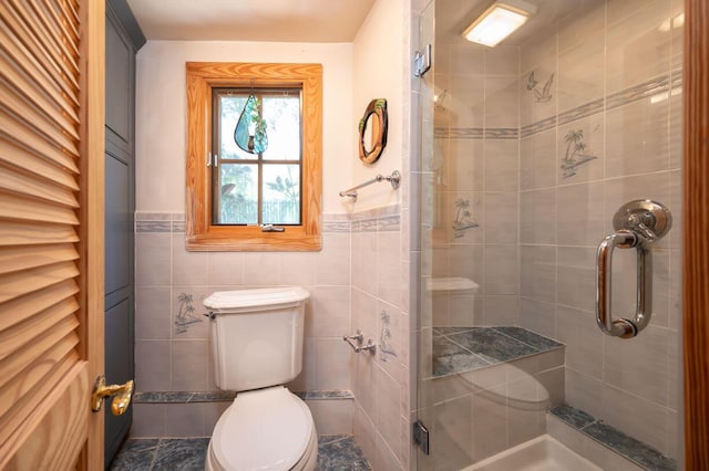 bathroom featuring tile walls, a shower with door, and toilet