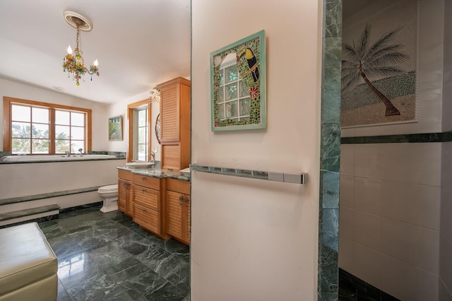 bathroom featuring vanity, toilet, a chandelier, and a shower