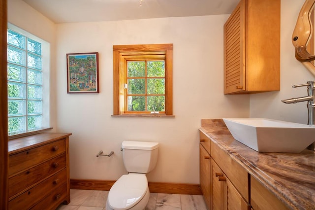 bathroom with plenty of natural light, toilet, and vanity