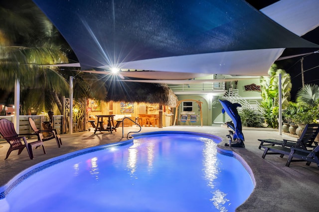 view of swimming pool with an outdoor bar and a patio