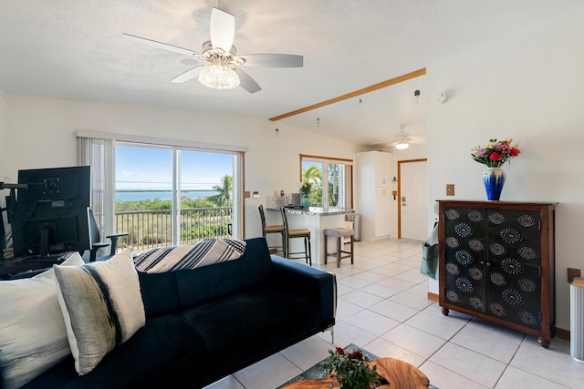 living room featuring light tile patterned flooring, ceiling fan, vaulted ceiling, and a textured ceiling