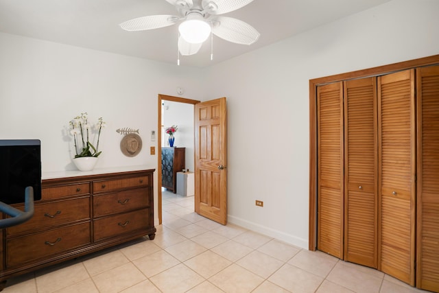 bedroom featuring light tile patterned flooring, ceiling fan, and a closet