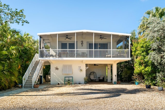 rear view of house featuring ceiling fan and a sunroom