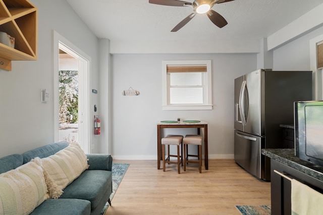 living room featuring ceiling fan and light hardwood / wood-style floors