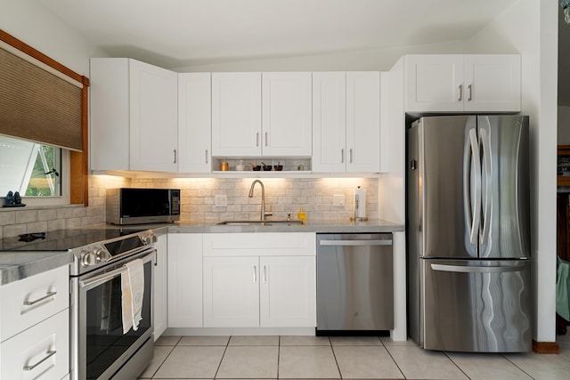 kitchen with white cabinetry, appliances with stainless steel finishes, sink, and decorative backsplash