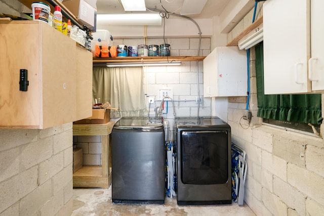 laundry area featuring separate washer and dryer and cabinets