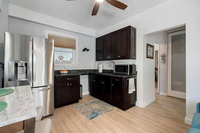 kitchen with sink, dark brown cabinetry, stainless steel appliances, a textured ceiling, and light hardwood / wood-style flooring