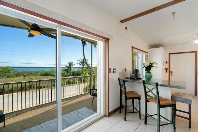 interior space featuring a water view, ceiling fan, and vaulted ceiling with beams