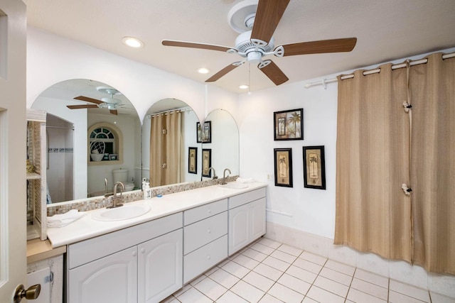 bathroom featuring tile patterned floors, toilet, a shower, vanity, and ceiling fan