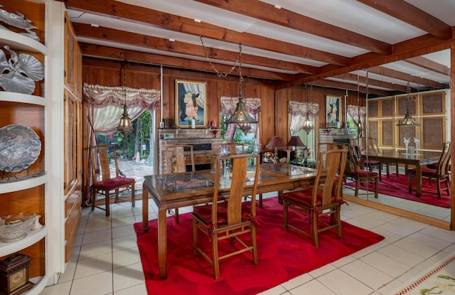 dining space with beamed ceiling, wood walls, and light tile patterned floors