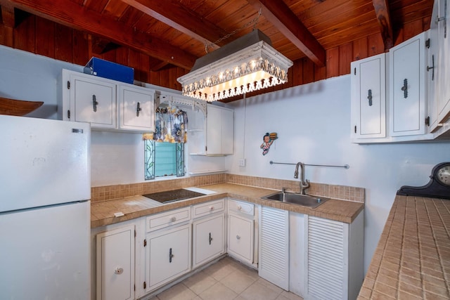 kitchen featuring sink, white refrigerator, black electric stovetop, white cabinets, and wooden ceiling