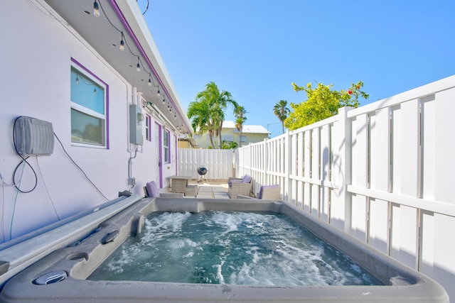 view of pool featuring a fenced backyard and a hot tub