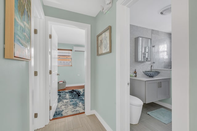 full bath with baseboards, decorative backsplash, tiled shower, toilet, and vanity