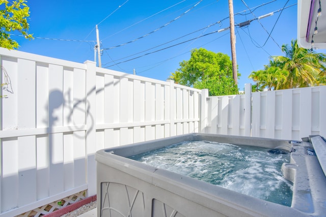 exterior space featuring fence and a hot tub