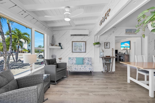 living room with beam ceiling, wood-type flooring, a wall unit AC, and ceiling fan