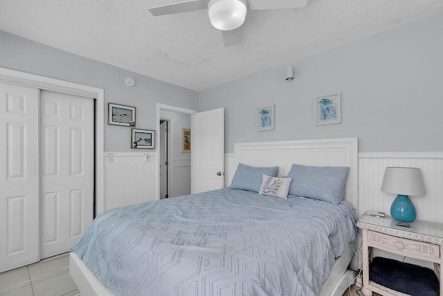 bedroom with ceiling fan, a closet, and a textured ceiling