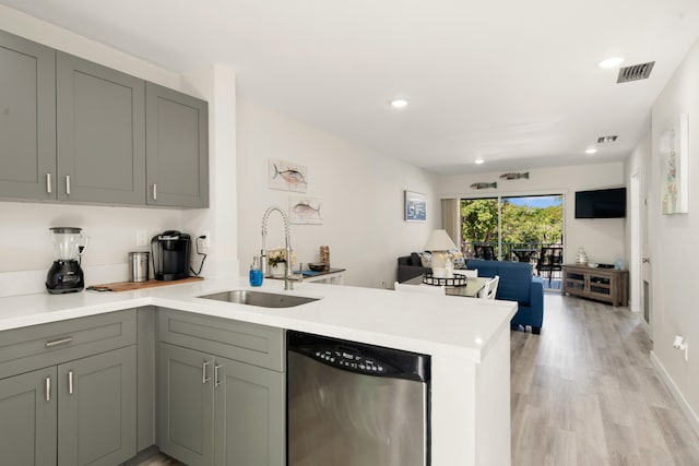 kitchen with sink, light hardwood / wood-style flooring, gray cabinets, stainless steel dishwasher, and kitchen peninsula