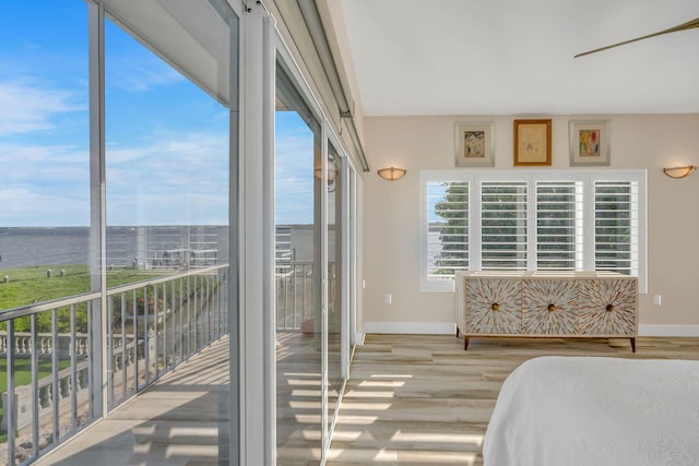 bedroom with access to exterior, baseboards, and wood finished floors