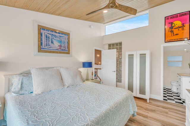 bedroom featuring a towering ceiling, wood ceiling, and light hardwood / wood-style floors