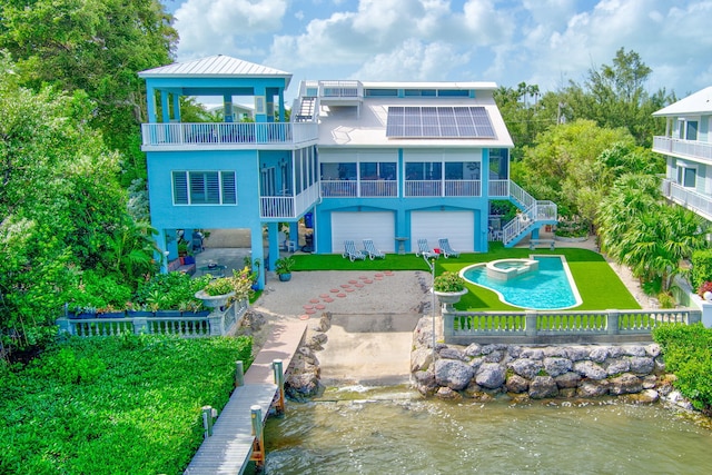 back of property with solar panels, a patio, a balcony, a sunroom, and stairway