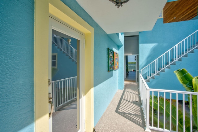 corridor with stairs and a textured wall