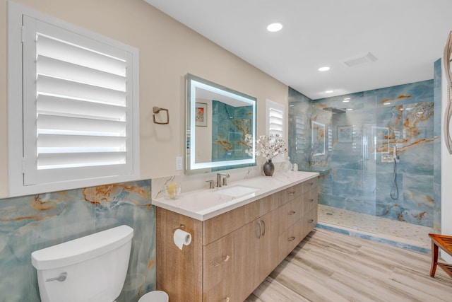 full bathroom with toilet, wood finished floors, vanity, visible vents, and a marble finish shower