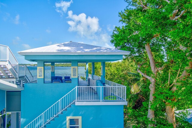 back of property featuring stairway, metal roof, a standing seam roof, a gazebo, and stucco siding