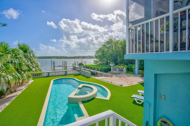 view of pool featuring a dock, a water view, and a pool with connected hot tub