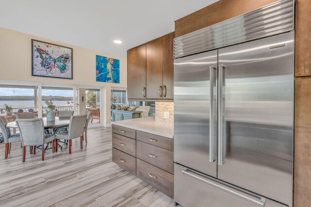 kitchen with built in fridge and light wood-type flooring