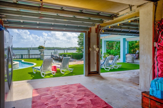 garage featuring a water view, a yard, and stainless steel refrigerator