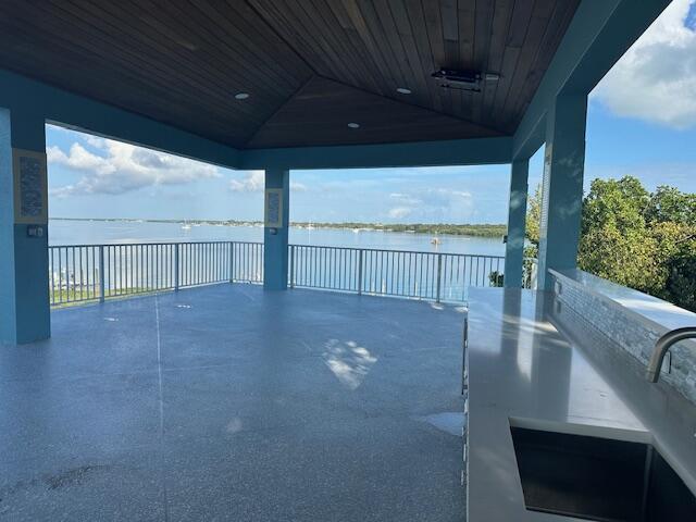 view of patio with a water view, sink, and a fire pit