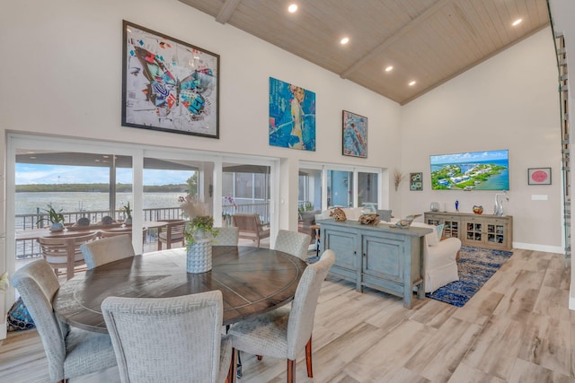 dining space featuring high vaulted ceiling, beamed ceiling, wood ceiling, a water view, and light wood-type flooring