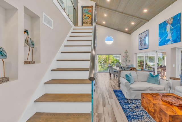 stairway with recessed lighting, visible vents, wood finished floors, high vaulted ceiling, and wooden ceiling