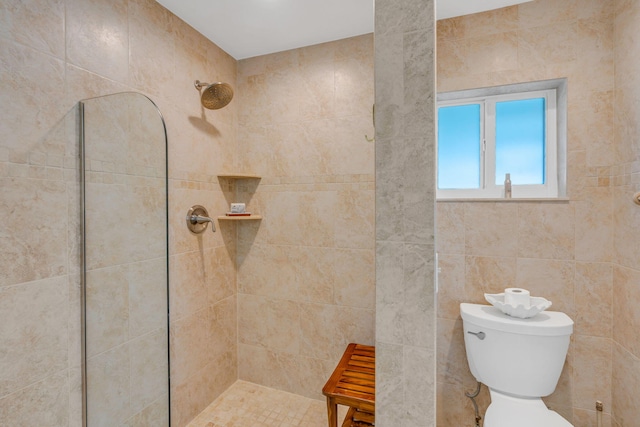 full bath with tiled shower and toilet