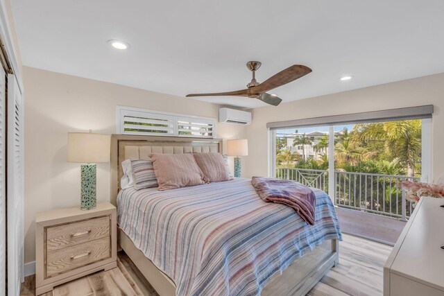 bedroom featuring access to outside, light hardwood / wood-style floors, an AC wall unit, and ceiling fan