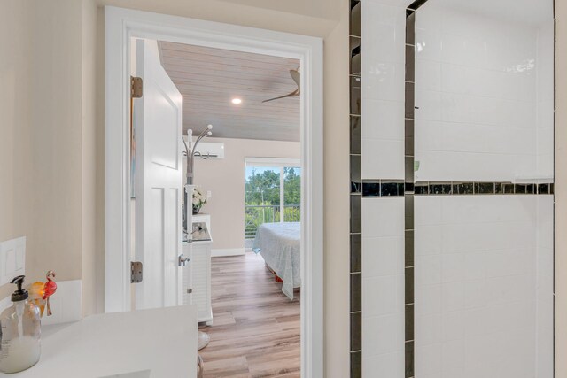 corridor with baseboards, wood finished floors, and recessed lighting