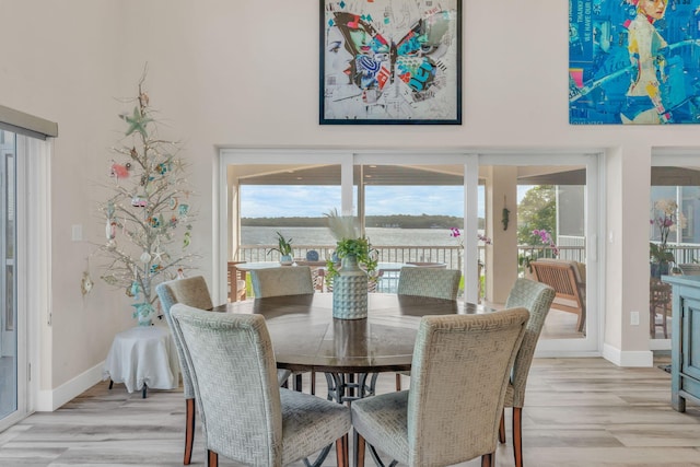 dining space featuring light wood-type flooring and baseboards