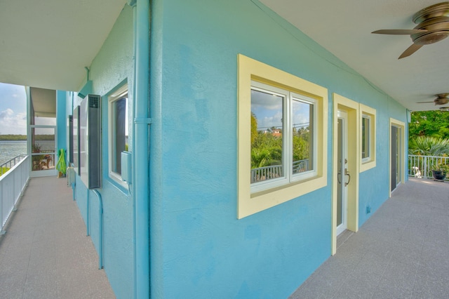 view of side of home featuring a ceiling fan and stucco siding