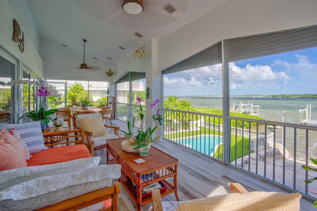 sunroom with vaulted ceiling, ceiling fan, and a water view