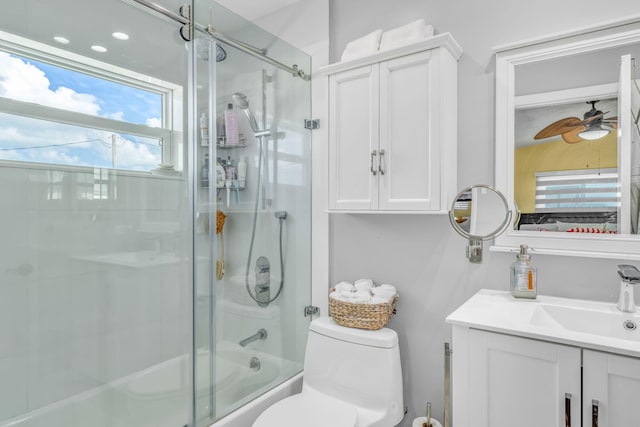full bath featuring combined bath / shower with glass door, toilet, a ceiling fan, and vanity