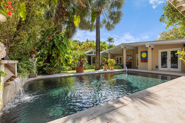 view of swimming pool with a patio area, a fireplace, and french doors