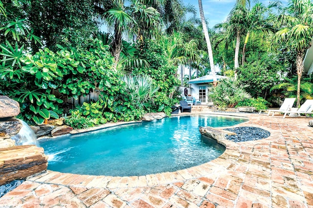 view of swimming pool featuring an outbuilding, a patio area, and pool water feature