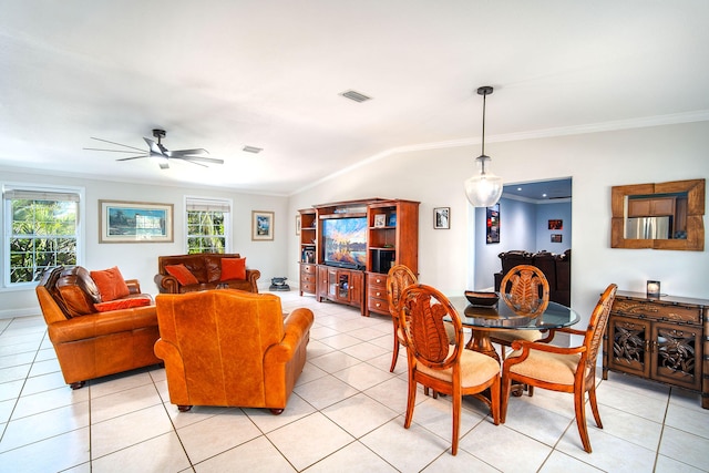 tiled dining area with lofted ceiling, ornamental molding, and ceiling fan