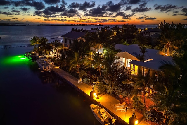 aerial view at dusk featuring a water view