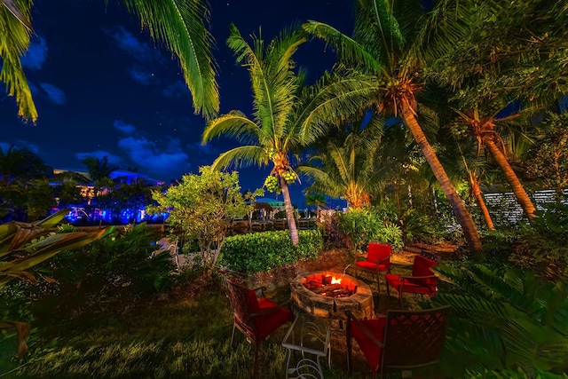 patio at night featuring an outdoor fire pit