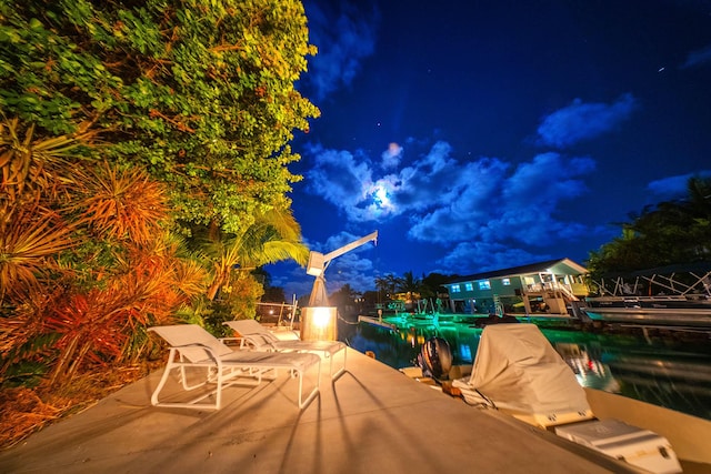 patio at night featuring a pool