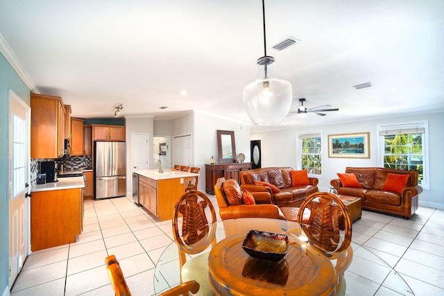 interior space featuring light tile patterned flooring, ceiling fan, ornamental molding, and sink