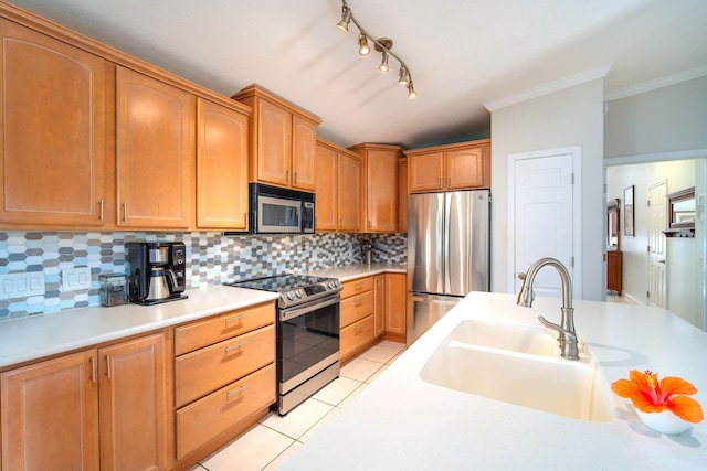 kitchen featuring backsplash, appliances with stainless steel finishes, sink, and light tile patterned floors