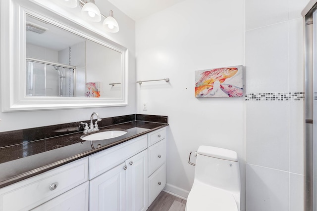 bathroom with vanity, an enclosed shower, and toilet