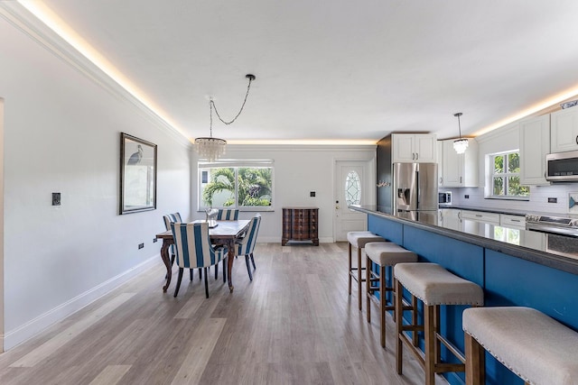 interior space with ornamental molding and light hardwood / wood-style floors